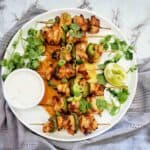 Air Fryer Chicken Skewers on a white plate with small bowl of sauce