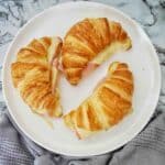 Air Fryer Croissants with ham and cheese on white plate