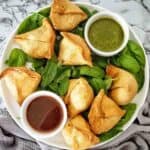 Air Fryer Samosas on white plate with sauce