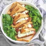 Sausages in bread with sauce in a bowl with herbs