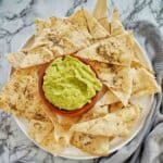 Avocado Sweet Chilli Dip in clay pot on white plate with pita chips