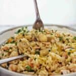 Fork being pushed into grey bowl of risotto.