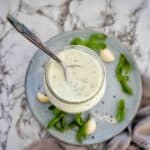 Basil Yogurt Sauce in tall glass with spoon on top