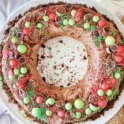 Chocolate Ripple Wreath cake with red and green toppings on a white cake platter