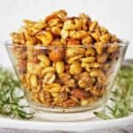 Nuts in a glass bowl on a white plate.