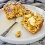 Cinnamon Oatmeal Muffin on white plate with butter and dusted icing sugar