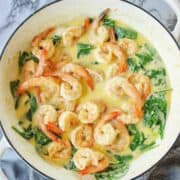 Creamy Garlic Prawns in a white pan with spinach and creamy sauce