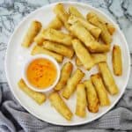 Air Fryer Frozen Spring Rolls with dipping sauce on white plate