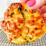 Garlic cheese roll being held above wire rack.
