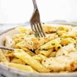 Fork in grey bowl of chicken pasta.