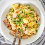 Fried rice with ham and pineapple pieces in white bowl.