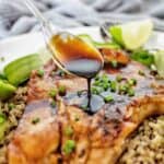 Honey glaze being drizzled over pork chop on white plate