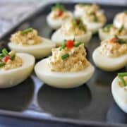Instant Pot Deviled Eggs on a black plate showing height of toppings