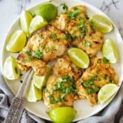 Mexican Lime Chicken on a white plate with fresh lime wedges