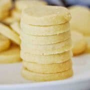 Stack of mini shortbread cookies piled on a white plate.