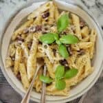 Pasta alla gorgonzola in grey bowl with fork and spoon