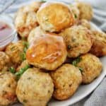 Meatballs with sauce stacked on white plate.