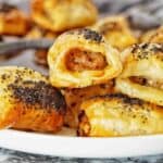 Pork and Fennel Sausage Rolls sprinkle with poppy seeds on white plate