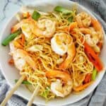 Prawn chow mein noodles in white bowl with chopsticks.