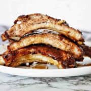 Slow cooked coke ribs on white plate.