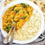 Dahl in white bowl with rice and naan bread.
