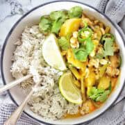 Beef yellow curry with rice in white bowl.