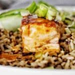 Teriyaki Glazed Salmon on white plate with rice and green onions