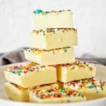 White chocolate fudge pieces stacked on a plate.